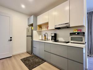 a kitchen with white cabinets and a stainless steel refrigerator at San Antonio Del Mar - Beachfront Studio for Two in San Antonio del Mar