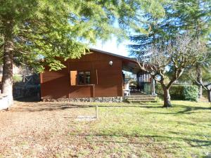 a brown house with a tree in front of it at La Baita Baretana 2 in Barete