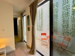 a room with a glass door with two chairs and a table at San Antonio Del Mar - Beachfront Studio for Two in San Antonio del Mar