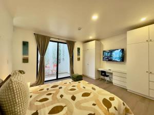 a bedroom with a bed and a desk and a television at San Antonio Del Mar - Beachfront Studio for Two in San Antonio del Mar