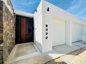 a white house with a black door at San Antonio Del Mar - Beachfront Studio for Two in San Antonio del Mar +11 photos