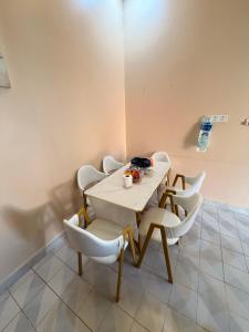 a dining room with a table and white chairs at NorvillaB Pantai Cenang in Pantai Cenang +6 photos
