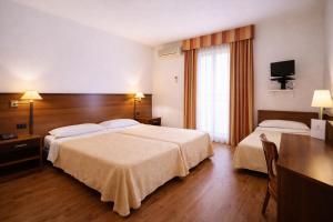 a hotel room with two beds and a desk at Hotel Bel Sit in Comerio +40 photos