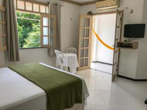 a bedroom with a bed and a tv and a window at Pousada do Mingote in Alter do Chao