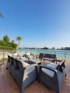 a group of tables and chairs on a patio overlooking the water at LA Brisa Durrat Alarous شاليهات لابريزا درة العروس شاطئ البرادايس للعوائل فقط in Durat Alarous