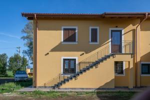 a yellow house with stairs on the side at Tenuta Marella in Santa Maria di Galeria