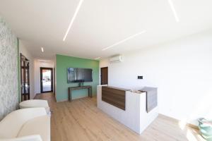 a living room with a couch and a tv at Tenuta Marella in Santa Maria di Galeria