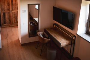 a room with a television and a desk with a mirror at Tenuta Marella in Santa Maria di Galeria +123 photos