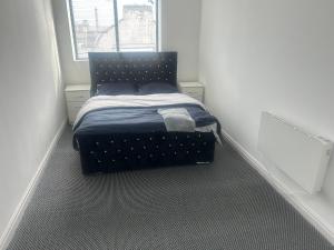 a small bedroom with a bed in a white room at The millstone residents in Bradford