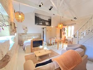 a living room with a couch and a tv at Moon in Flaugnac