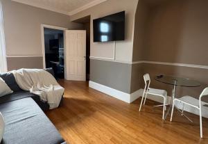 a living room with a couch and a table and chairs at Spacious 2 BR Flat in Gateshead - Free Parking in Gateshead