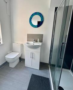 a bathroom with a toilet and a sink and a mirror at Spacious 2 BR Flat in Gateshead - Free Parking in Gateshead