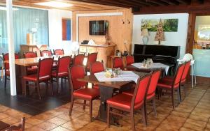 ein Esszimmer mit Tischen und roten Stühlen in der Unterkunft Hotel Pension Löwen nahe Feldkirch - günstige Zimmer für Urlauber, Firmen und Monteure in Sulz