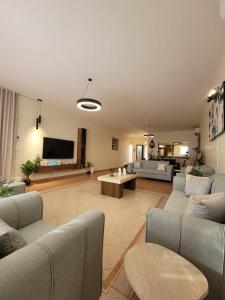 a large living room with couches and a flat screen tv at LA Brisa Durrat Alarous شاليهات لابريزا درة العروس شاطئ البرادايس للعوائل فقط in Durat Alarous
