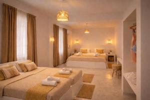 a bedroom with two beds with towels on them at Noème Santorini in Perissa +44 photos