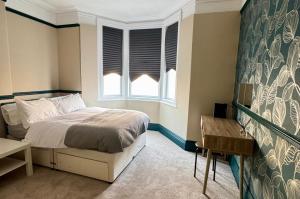 a bedroom with a bed and two windows at Spacious 2 BR Flat in Gateshead - Free Parking in Gateshead