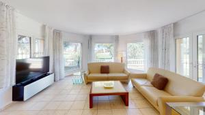 a living room with two couches and a flat screen tv at Greenview Villa by ON Travel in Oliva