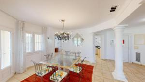 a dining room with a glass table and chairs at Greenview Villa by ON Travel in Oliva