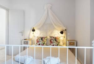 a white bed with a canopy in a bedroom at Katerina Irida in Mérikhas
