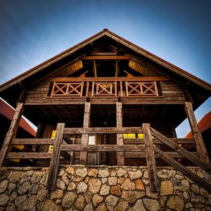 a large wooden building with a fence in front at Chalé do Zêzere in Cortes do Meio