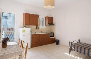 a kitchen with a table and a white refrigerator at Katerina Irida in Mérikhas