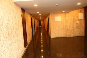 an empty hallway with tile walls and a long corridor at sas square hotels in Tiruchirappalli