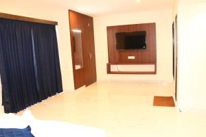 a living room with a tv and a large curtain at sas square hotels in Tiruchirappalli
