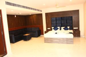 a bedroom with a bed and a couch at sas square hotels in Tiruchirappalli