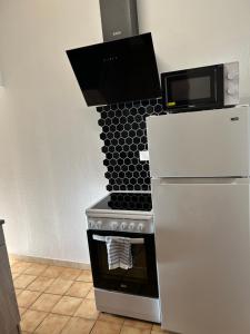 a kitchen with a stove and a microwave at Studio Le Vale - Centre Ville de Givet in Givet