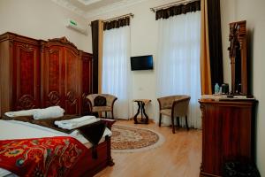 a bedroom with a bed and a desk and chairs at Imperial Palace Bukhara in Bukhara