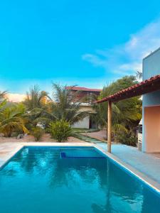 a blue swimming pool in front of a house at Refugio tropical icarai in Icaraí