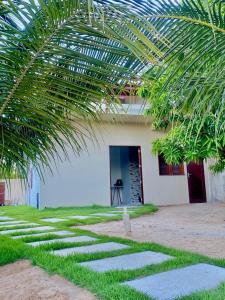 a stone path leading to a house with a palm tree at Refugio tropical icarai in Icaraí