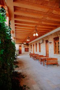 a row of tables and benches in a building at Imperial Palace Bukhara in Bukhara