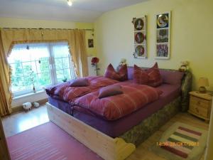 a bedroom with a large bed with red pillows at Ferienwohnung Ferien im Dorf in Bleckhausen +48 photos