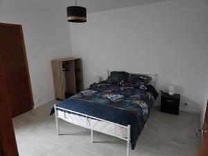 a bedroom with a bed in a white room at Appartement Le Gwen - Centre Ville de Givet in Givet