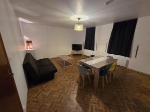 a living room with a dining room table and chairs at Appartement Le Gwen - Centre Ville de Givet in Givet