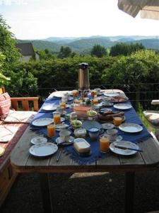 a wooden table with plates of food and orange juice at Ferienwohnung Ferien im Dorf in Bleckhausen