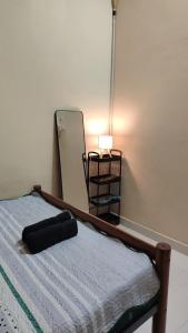 a bed in a room with a mirror and a bed sidx sidx sidx at MQ Homestay in Temerloh