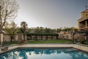 a large swimming pool in front of a building at Hotel Finca El Peregrino in Puente la Reina