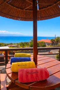 three towels sitting on a wooden table with an umbrella at Lucy's Rosegarden in Urzelina
