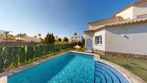 a swimming pool in a yard next to a house at Greenview Villa by ON Travel in Oliva