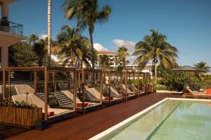 a resort with a pool and lounge chairs next to a swimming pool at Secrets Playa Mujeres Golf & Spa Resort - All Inclusive Adults Only in Cancún