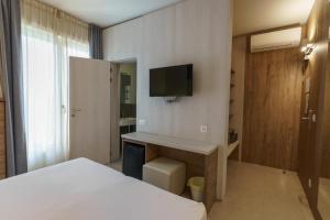 a bedroom with a bed and a desk with a television at Albergo Morgana in Mendrisio