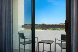 a room with a balcony with chairs and a table at Courtyard Columbus Worthington in Worthington