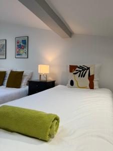 a bedroom with two white beds and a lamp at Bastille in Tournon-sur-Rhône