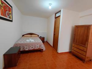 a bedroom with a bed and a wooden cabinet at HOSPEDAJE D`NOA En el centro de Oxapampa in Oxapampa +5 photos