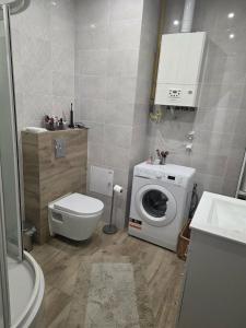 a bathroom with a washing machine and a toilet at Apartament M&G in Jarosław