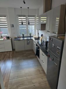 a kitchen with stainless steel appliances and wooden floors at Apartament M&G in Jarosław +3 photos