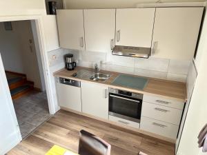 a small kitchen with white cabinets and a sink at Ferienwohnung Erhol Dich Gut in Diez