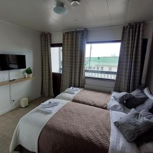 a hotel room with two beds and a window at Hotel Sommarvind in Inkoo